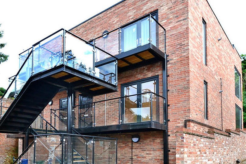 mursten kontorbygning med sorte balkondøre